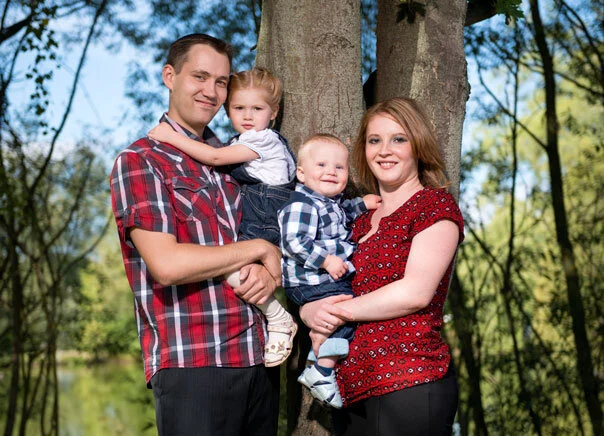 Familie unter Bäumen | Peter Lauritis Photography Outdoor-Fotoshooting im Herbst: junge Familie mit zwei Kindern vor Baumstämmen am Wasser