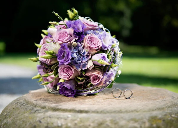 Brautstrauß mit Ringen | Peter Lauritis Photography Hochzeitsfotografen früh buchen: fliederfarbener Brautstrauß mit Eheringen auf Stein