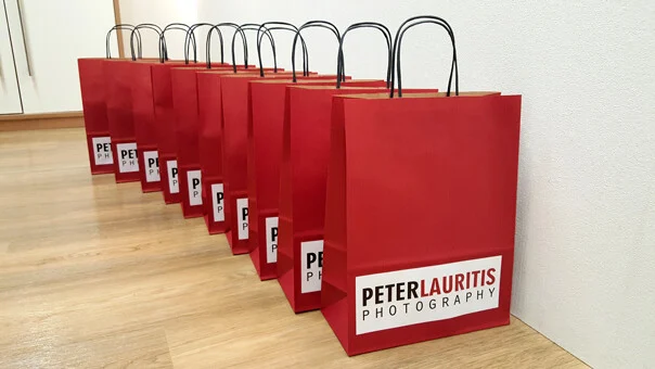 Geschenktüten Tombola | Peter Lauritis Photography Weihnachtstombola 2015: zehn rote Geschenktüten mit unserem Logo in einer Reihe
