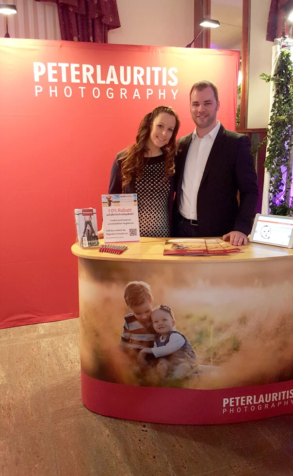 Messestand Hochzeitsmesse | Peter Lauritis Photography Hochzeitsmesse im Landgasthof Bechtel: zwei Personen hinter unserem roten Messestand