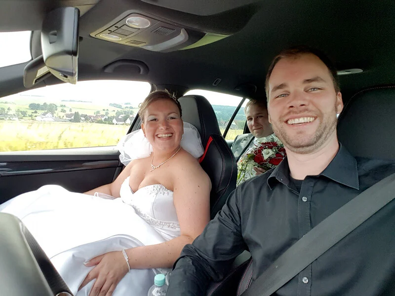 Brautpaar-Tour im Auto | Peter Lauritis Photography Hochzeitsfotos im Heimatort: Braut und Fotograf lachen bei der Fahrt zum nächsten Fotoort