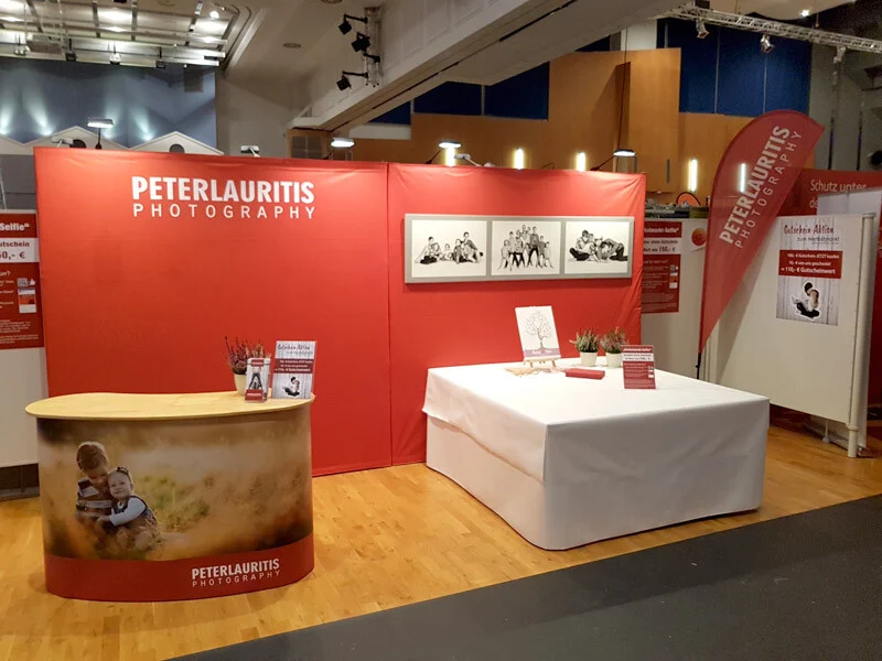 Messestand Herbstmarkt | Peter Lauritis Photography Messestand auf dem Herbstmarkt: roter Stand mit Logo, Familienfotos und Beachflag
