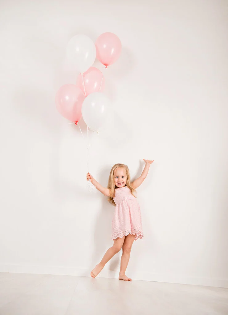 Mädchen mit Luftballons | Peter Lauritis Photography Kinderfotos mit Luftballons: Mädchen im rosa Kleid mit rosa und weißen Ballons vor weißer Wand