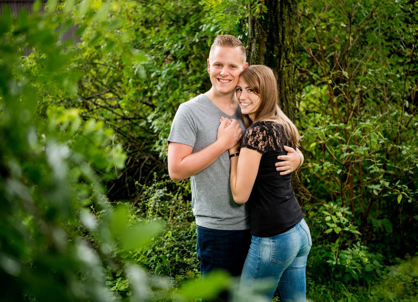 Paar im Grünen | Peter Lauritis Photography Outdoorshooting im Frühling: lachendes Paar umarmt sich inmitten von frischem Grün
