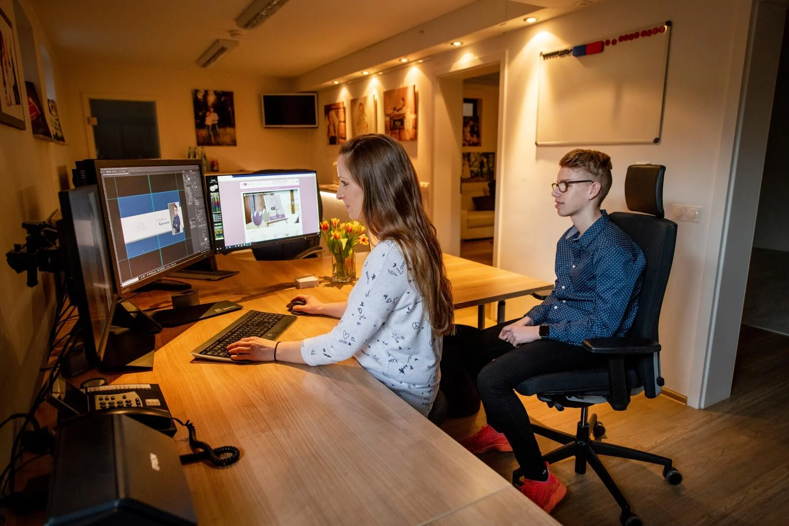Fotoauswahl | Peter Lauritis Photography Mitarbeiterin und Junge sitzen am Schreibtisch und schauen gemeinsam Fotos am Bildschirm an