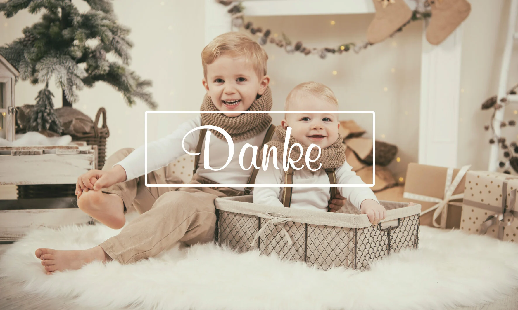 Weihnachts-Fotoaktion: zwei Brüder im Drahtkorb vor Weihnachtskulisse mit dem Schriftzug Danke
