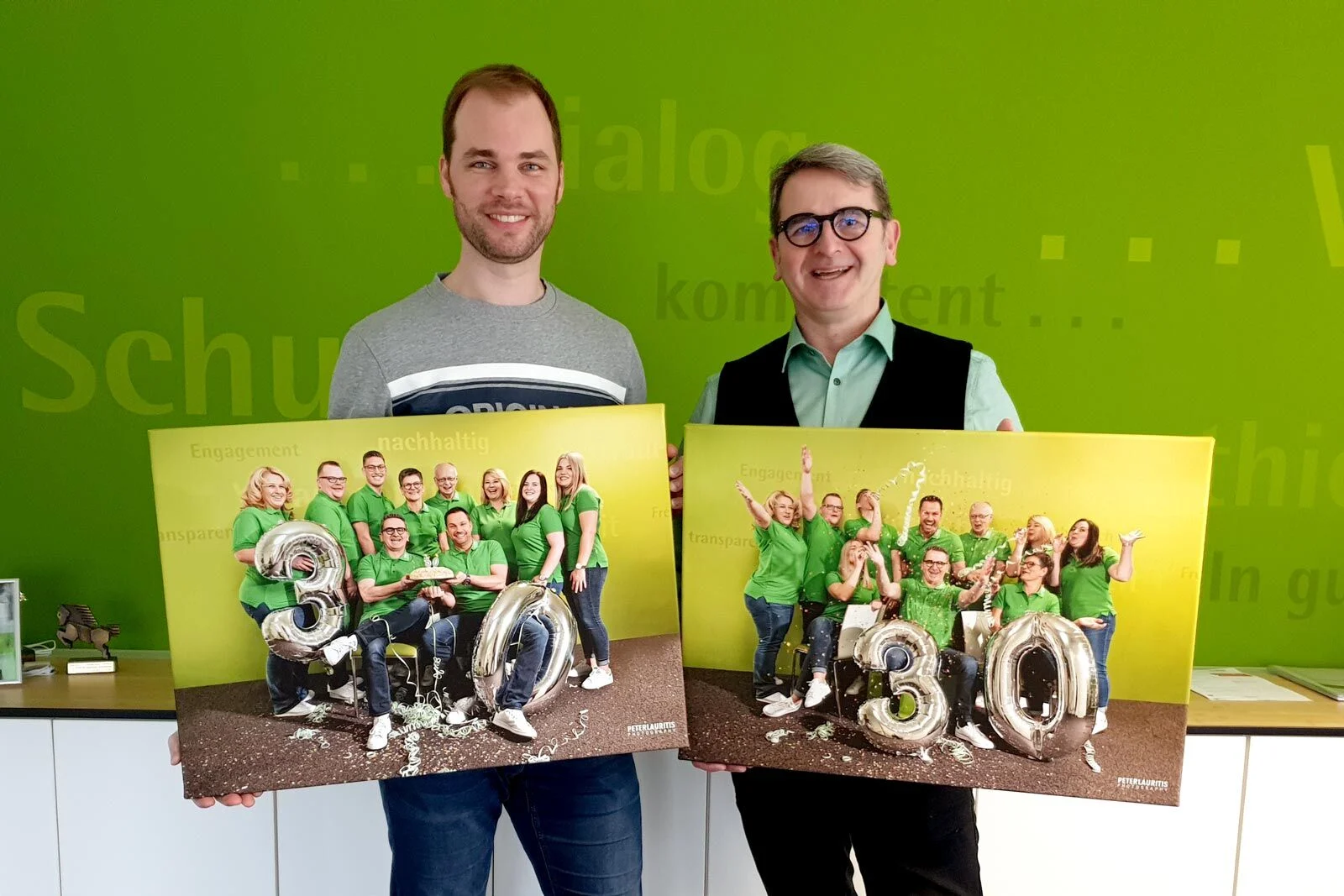 Leinwände zum Jubiläum | Peter Lauritis Photography Firmenjubiläum: zwei Männer halten Leinwände mit Teamfotos und silbernen Ballons 30