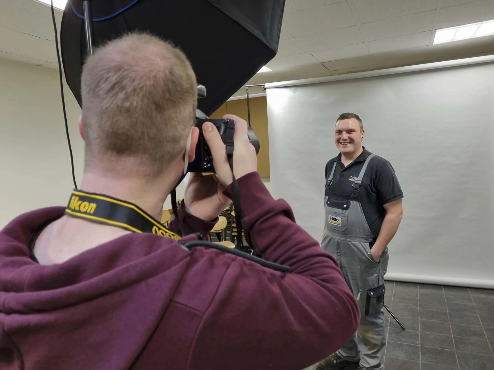 Fotograf von hinten beim Fotografieren eines Mitarbeiters im mobilen Studio