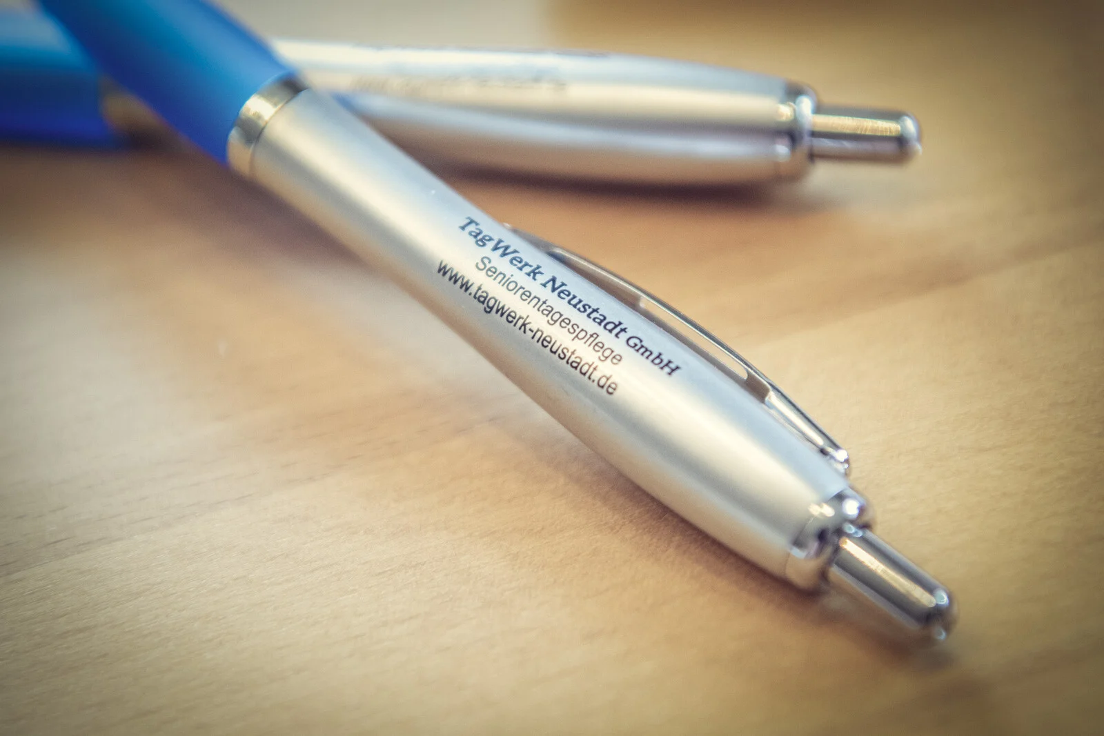 Nahaufnahme eines Kugelschreibers mit Aufdruck TagWerk Neustadt GmbH und Webadresse