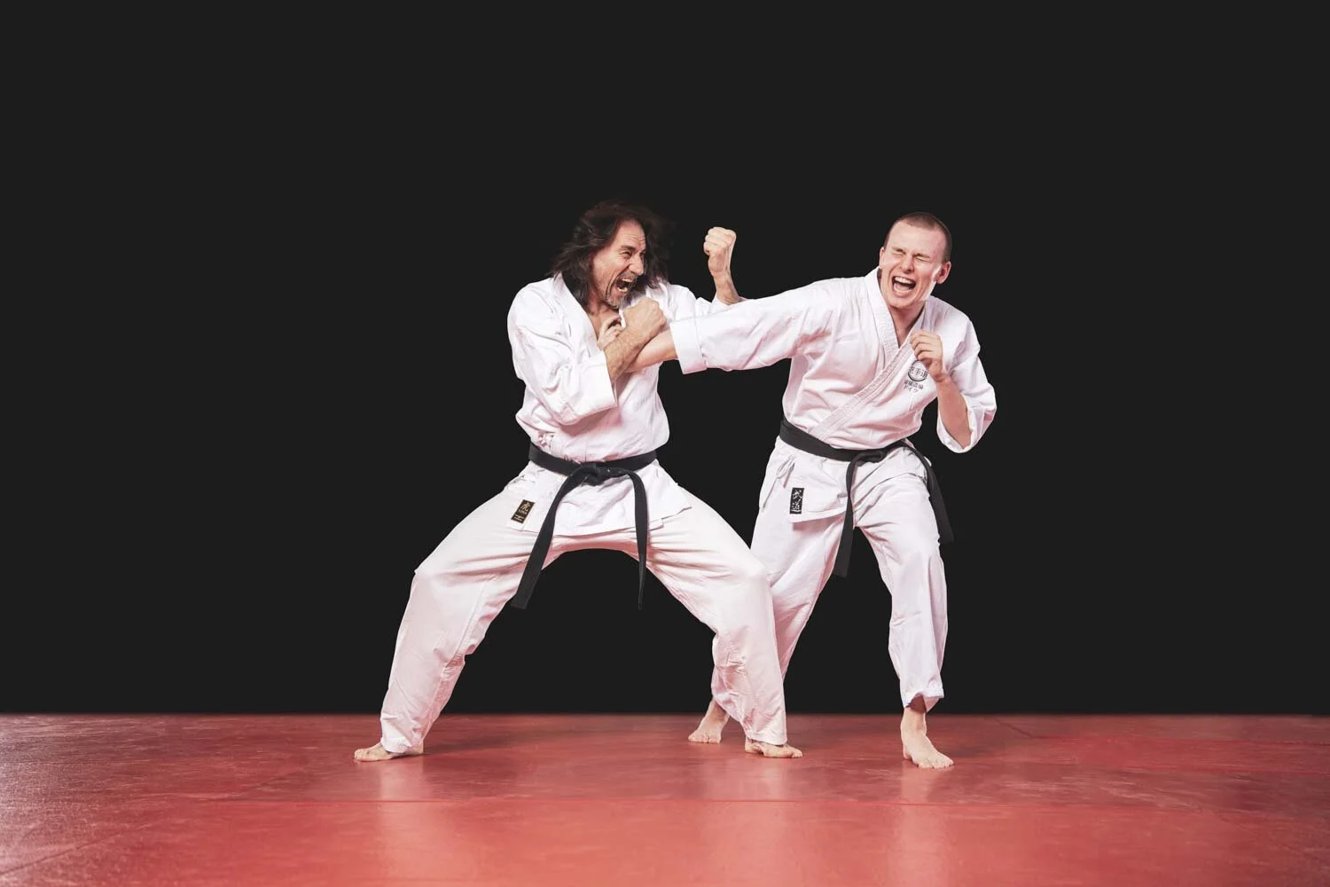 Kampfkunstzentrum-Training: Karateka blockt einen Schlag seines Partners ab