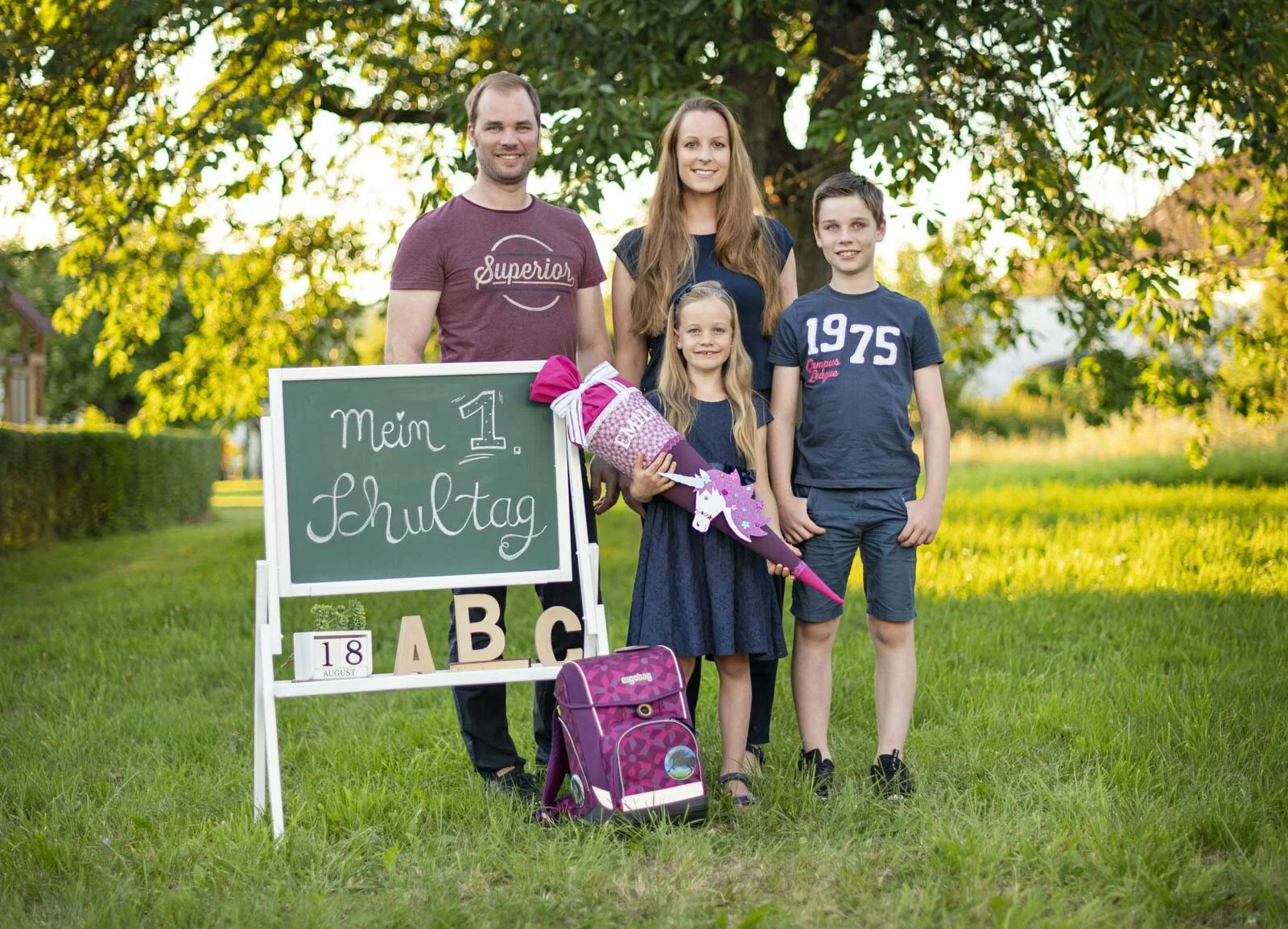 Einschulungsfotos: Familie mit Schulkind und Bruder vor der Tafel Mein 1. Schultag