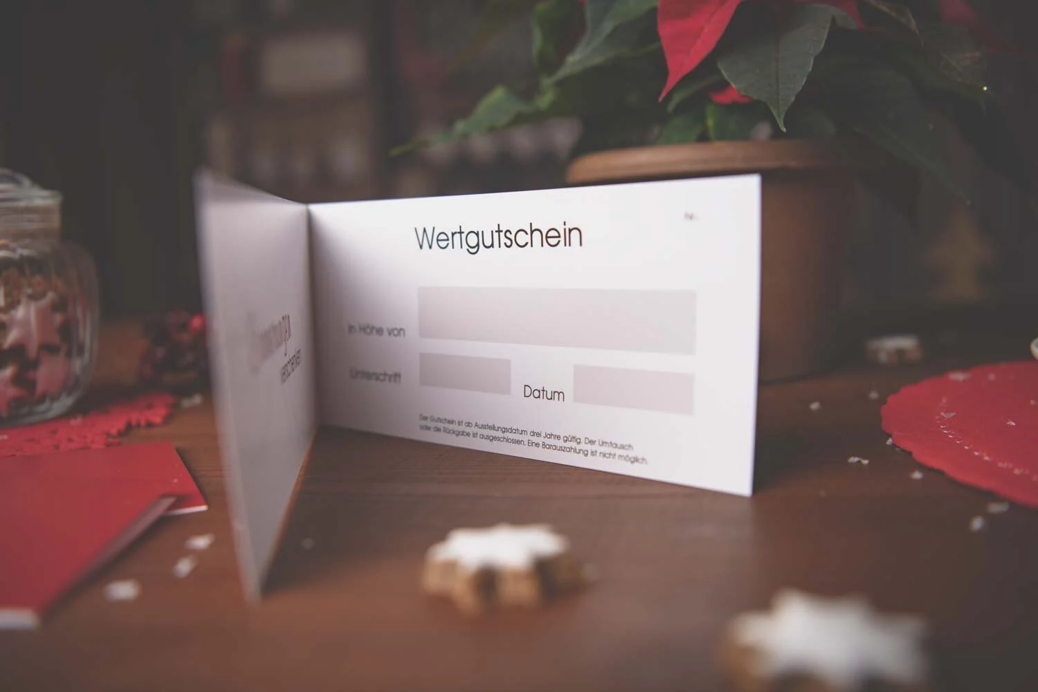 Gutschein-Aktion zu Weihnachten: aufgestellter Wertgutschein vor einem Weihnachtsstern