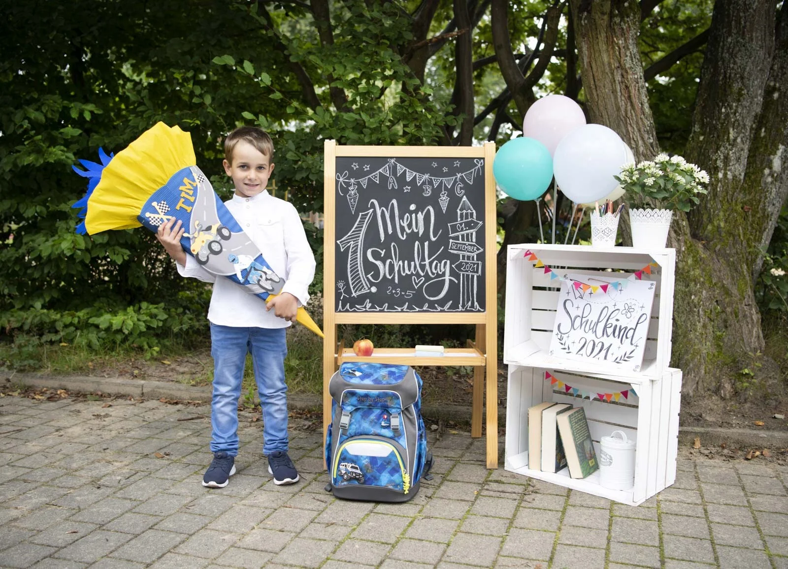 Einschulung: Junge mit Schultüte neben Schulranzen, Tafel Mein 1. Schultag und Ballons