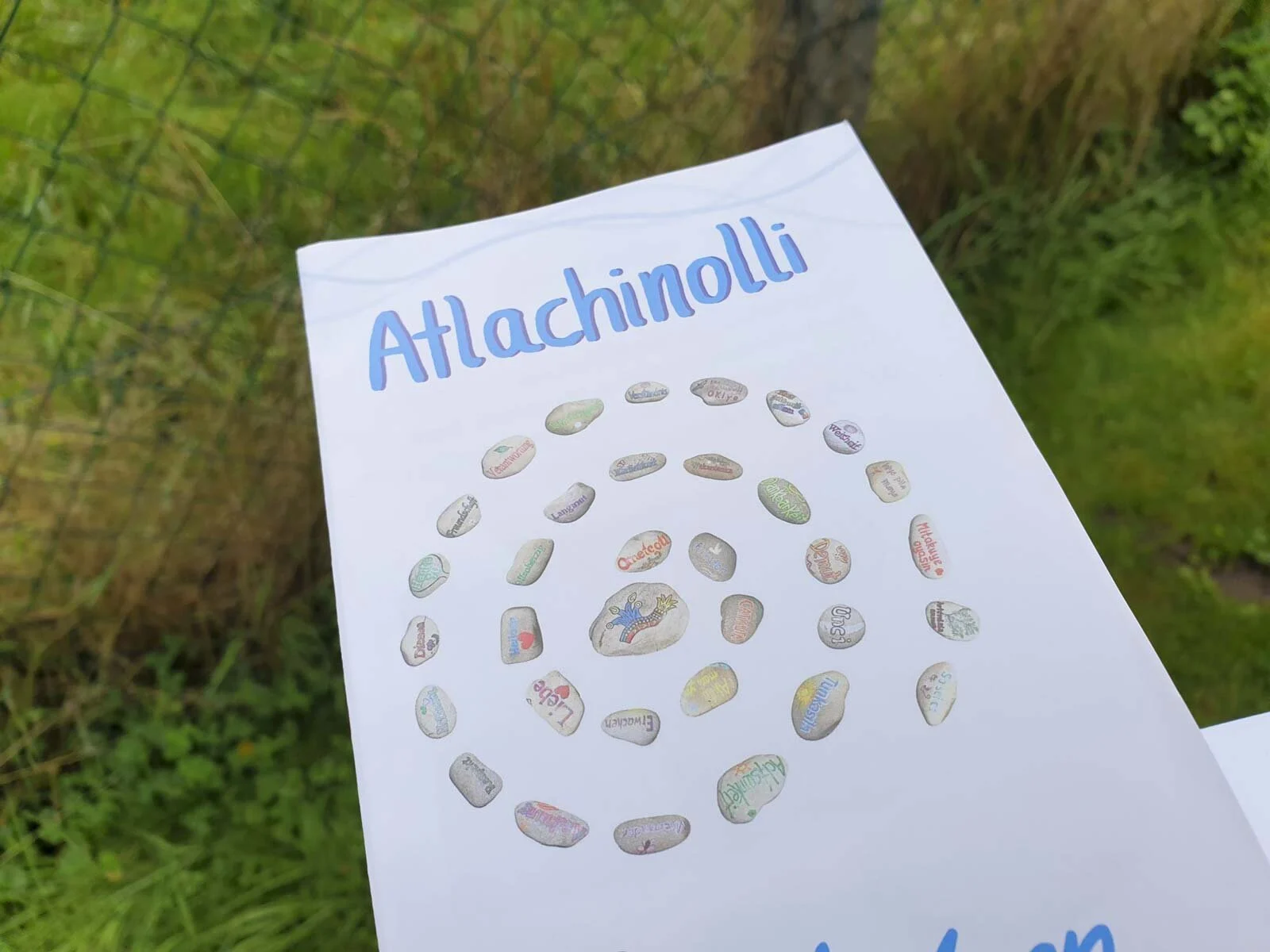 Atlachinolli: Flyer mit einer gezeichneten Steinspirale im Gras