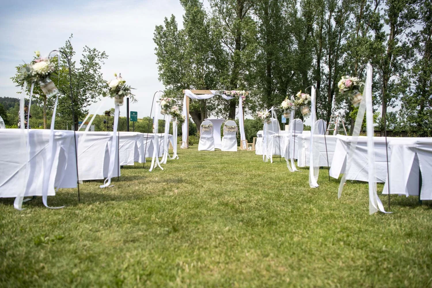 Walkemühle Frankenberg: Mittelgang auf der Wiese zwischen weißen Sitzreihen zum Traubogen
