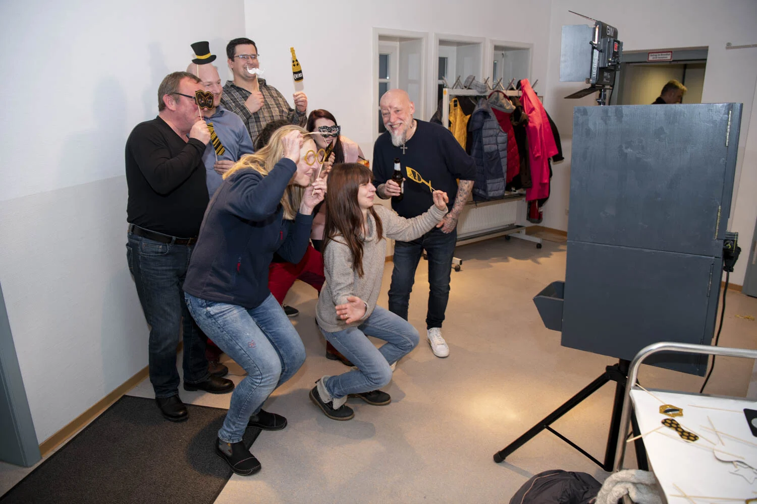 Gruppe mit Requisiten posiert vor der Fotobox