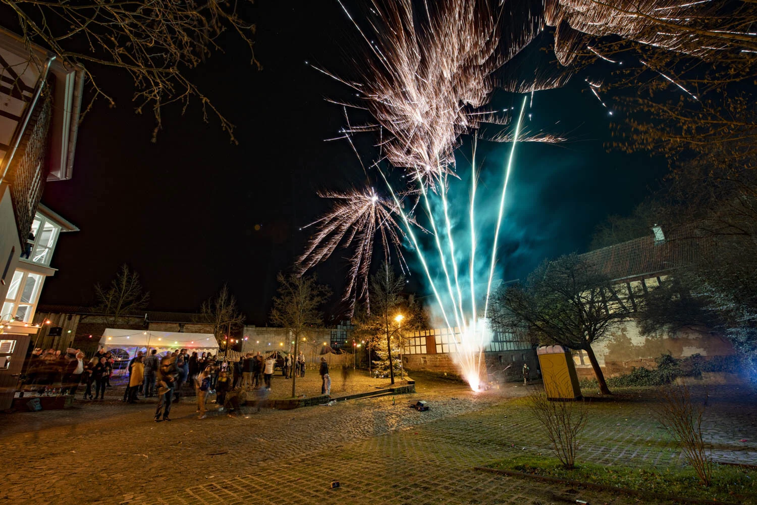 Bunte Feuerwerksfontänen am Rand des Dorfplatzes