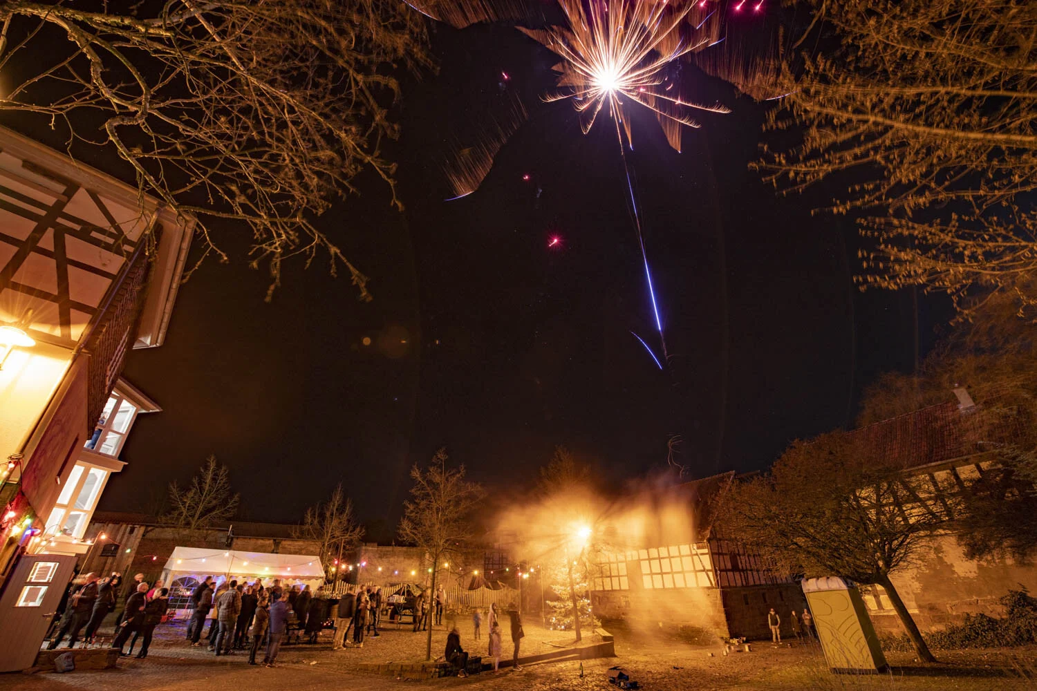 Rakete explodiert über dem Dorfplatz, darunter Gäste