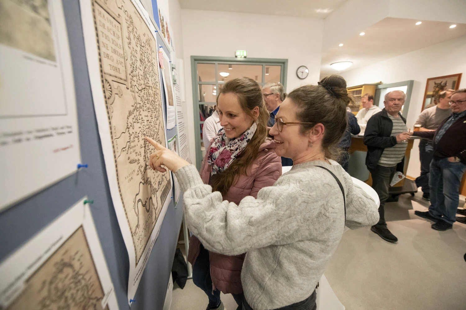 Zwei Frauen betrachten eine historische Karte an der Wand