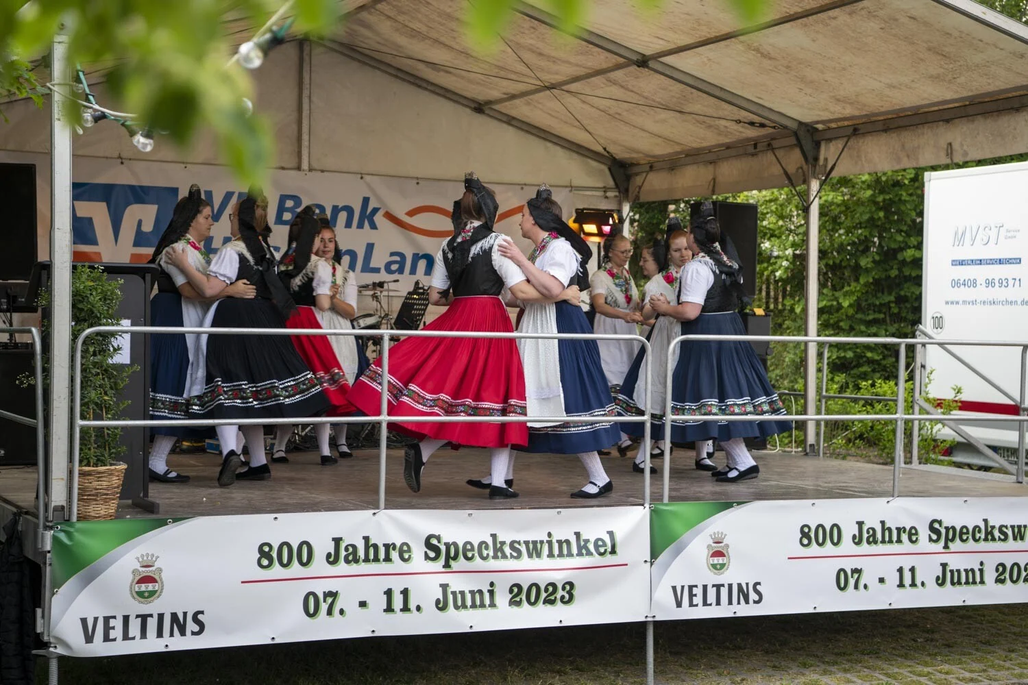 Tänzerinnen in roten und blauen Röcken tanzen auf der Bühne