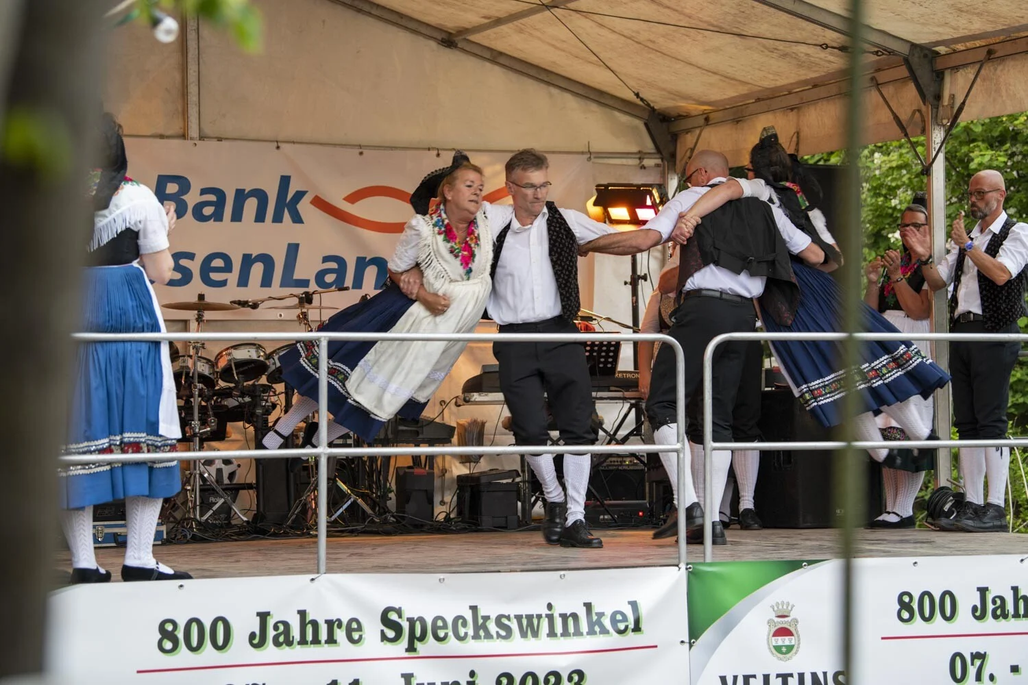 Paare in Tracht tanzen auf der Bühne