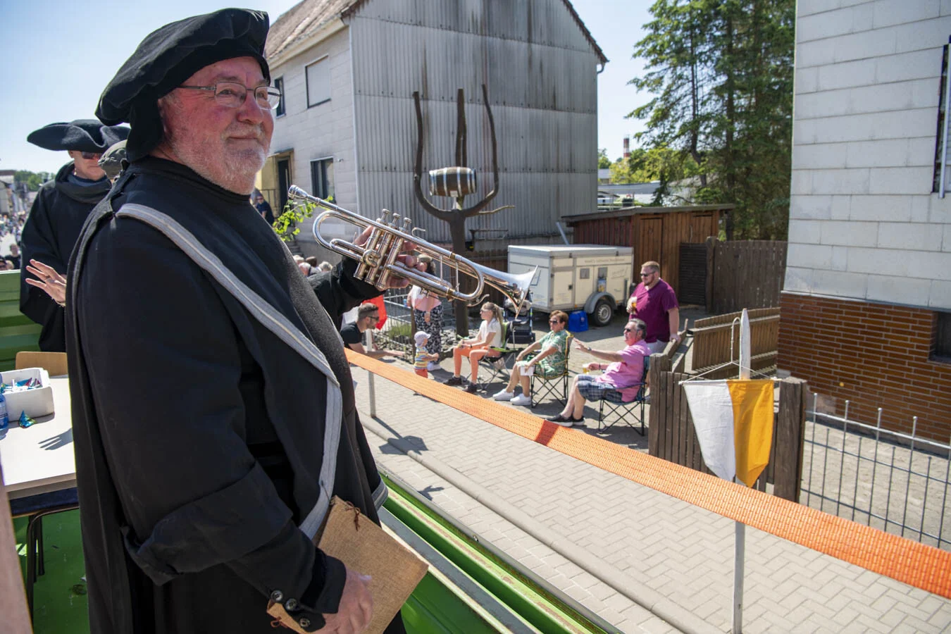 Darsteller mit schwarzem Barett und Umhang auf dem Festwagen