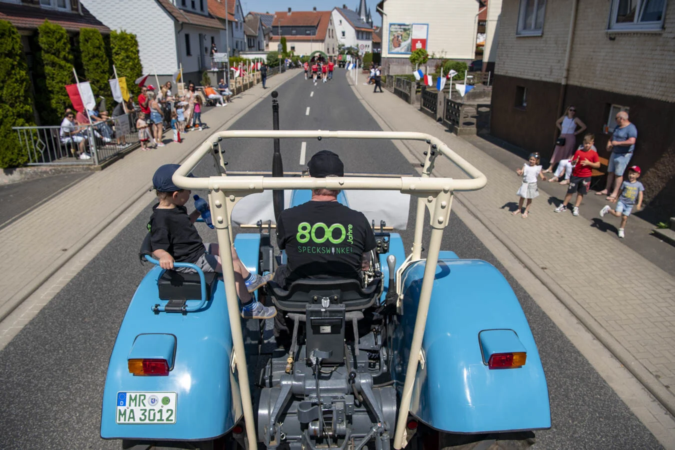 Blauer Traktor mit Fahrer im Shirt mit der Aufschrift 800
