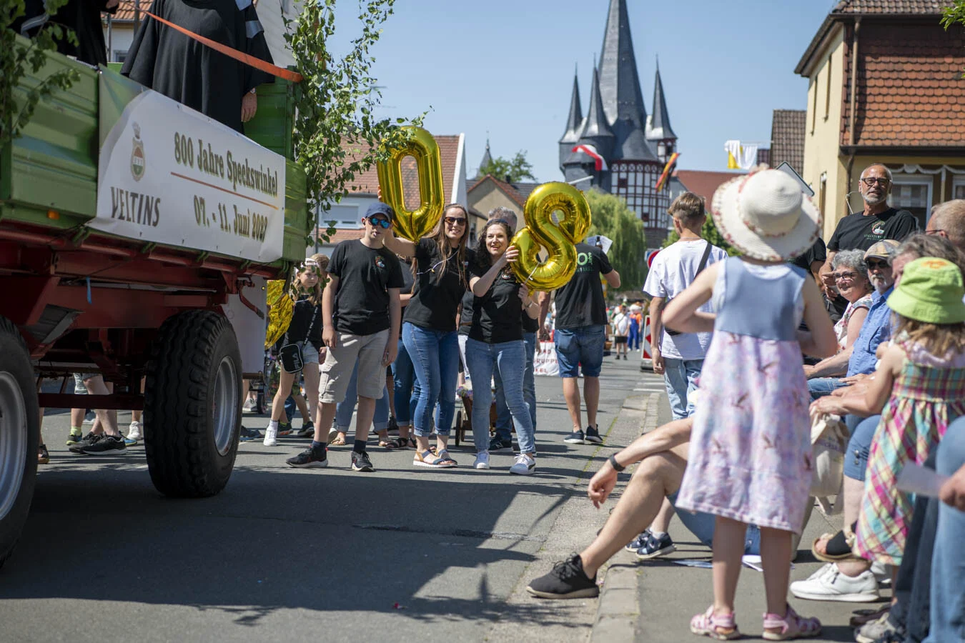 Zuschauer am Straßenrand, im Festzug goldene Ballons in Form der 800