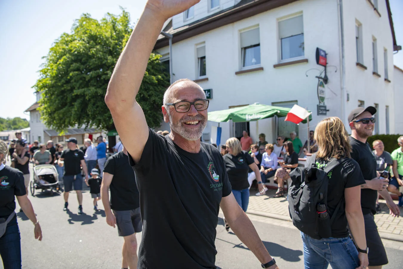 Trinitatis Kirmes in Neustadt: lachender Mann winkt im Festzug