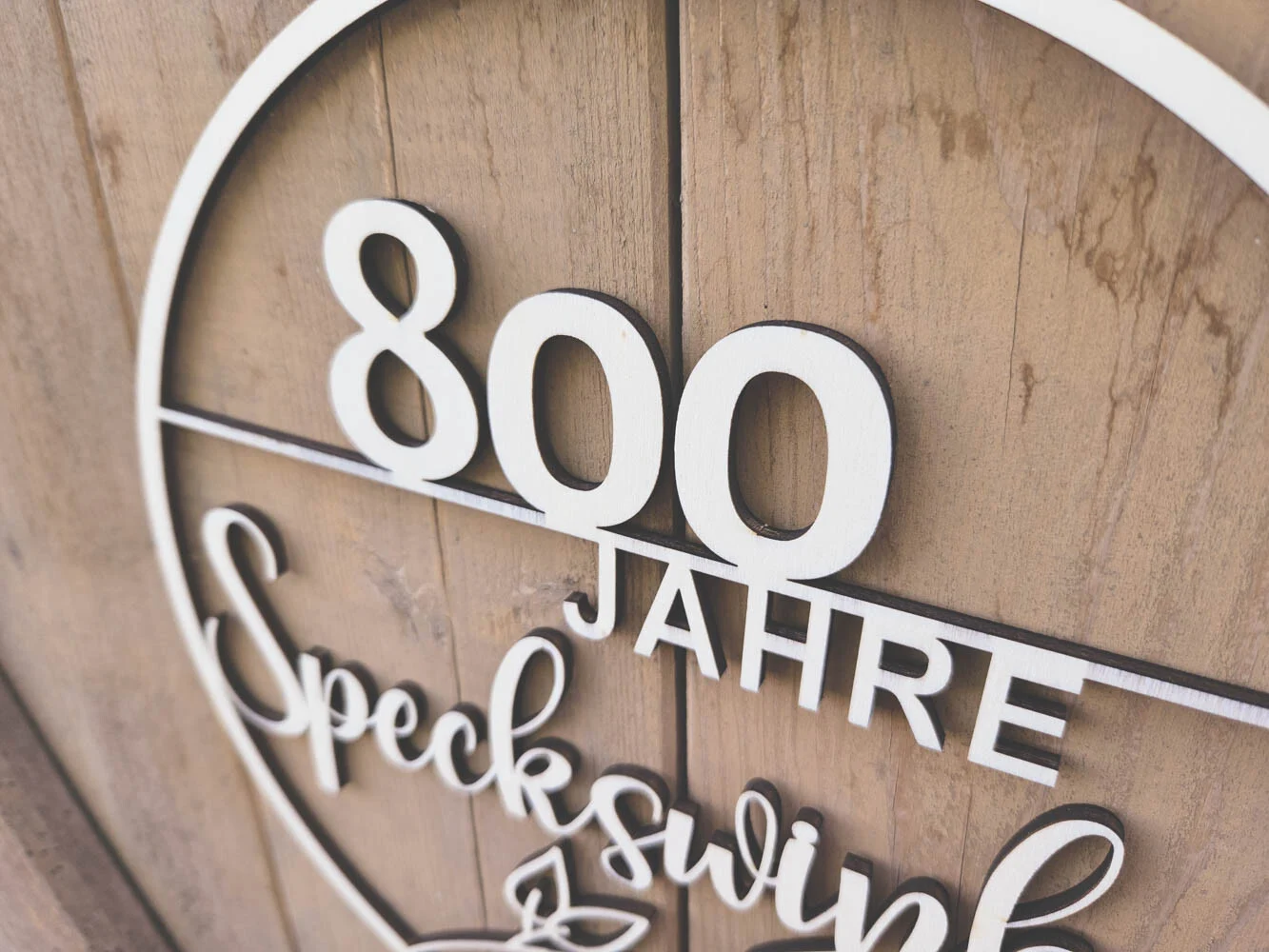 Laser-Holzschnitt aus der Nähe: die Zahl 800 und das Wort JAHRE auf hellem Holz