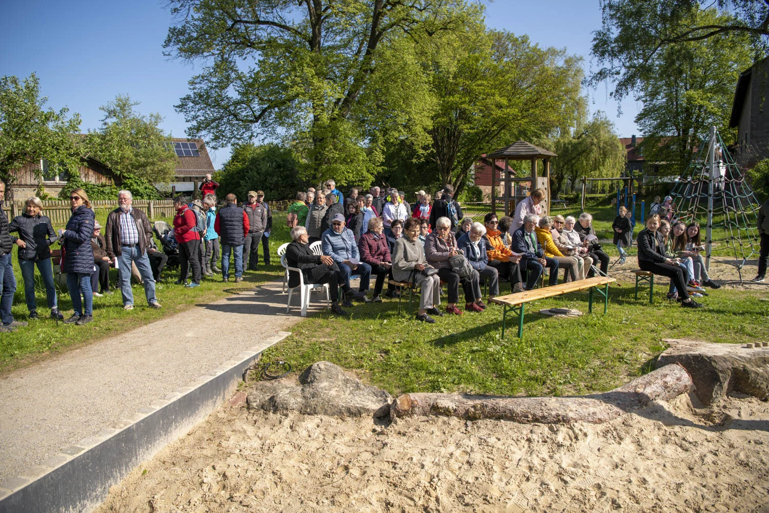 Grenzgang in Speckswinkel: viele Gäste stehen und sitzen zur Andacht auf einer Wiese
