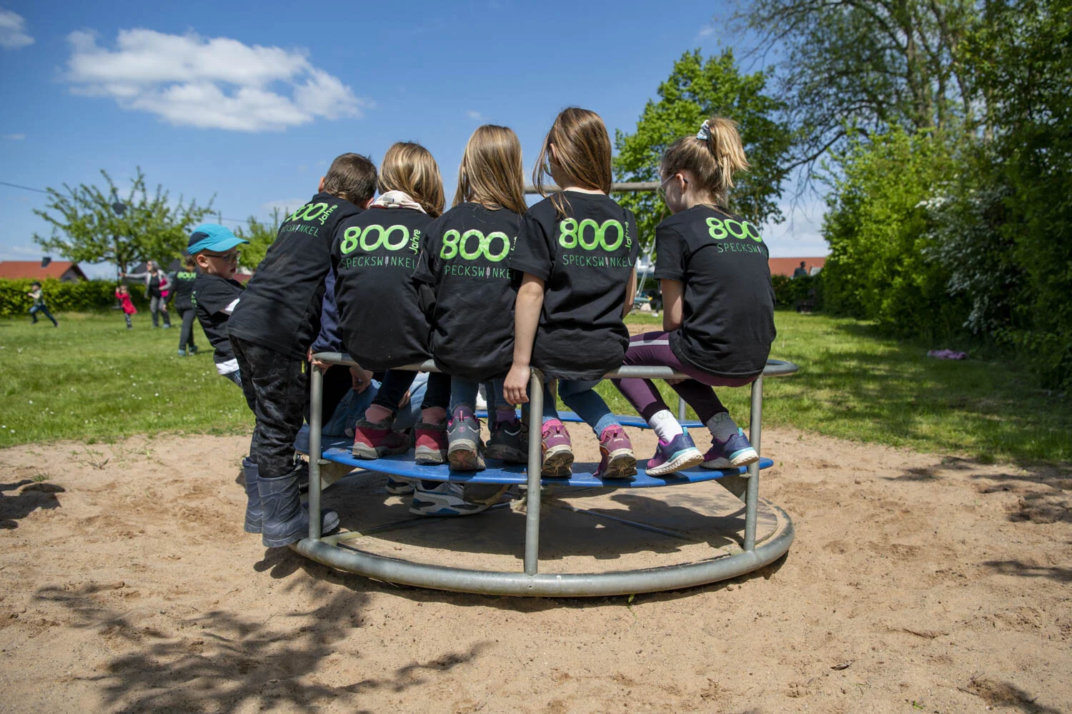Grenzgang – Kinder auf dem Karussell | Peter Lauritis Photography Grenzgang: Kinder in Shirts mit der Aufschrift 800 sitzen auf einem Karussell