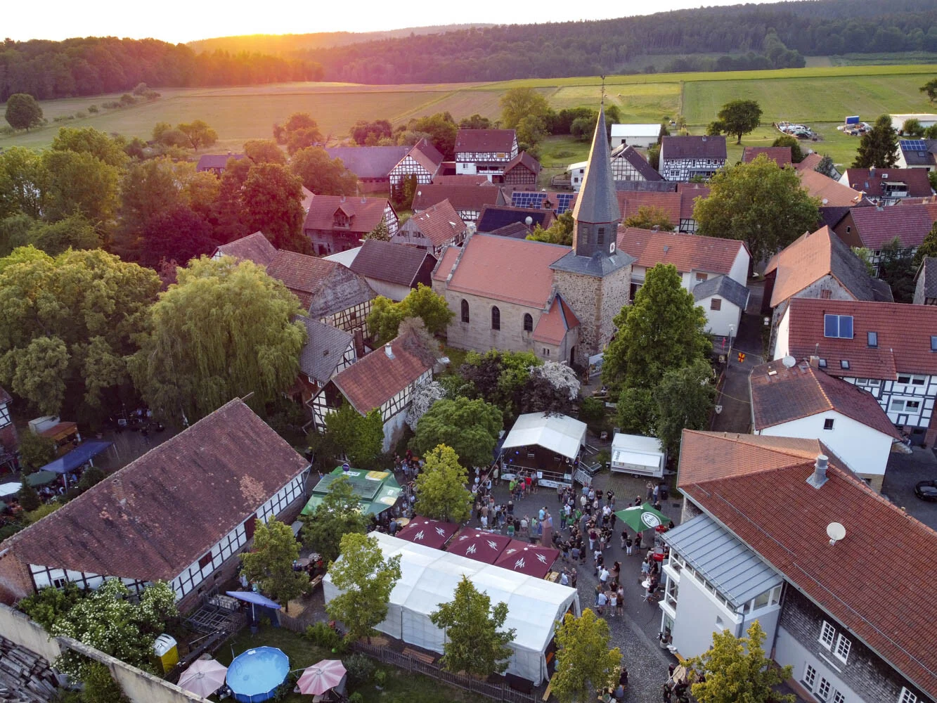 Höfe- und Scheunenfest: Luftaufnahme von Speckswinkel mit Kirche und Festzelten im Abendlicht