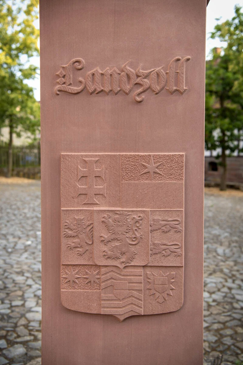 Inschrift Landzoll in alter Schrift über einem gemeißelten Wappen