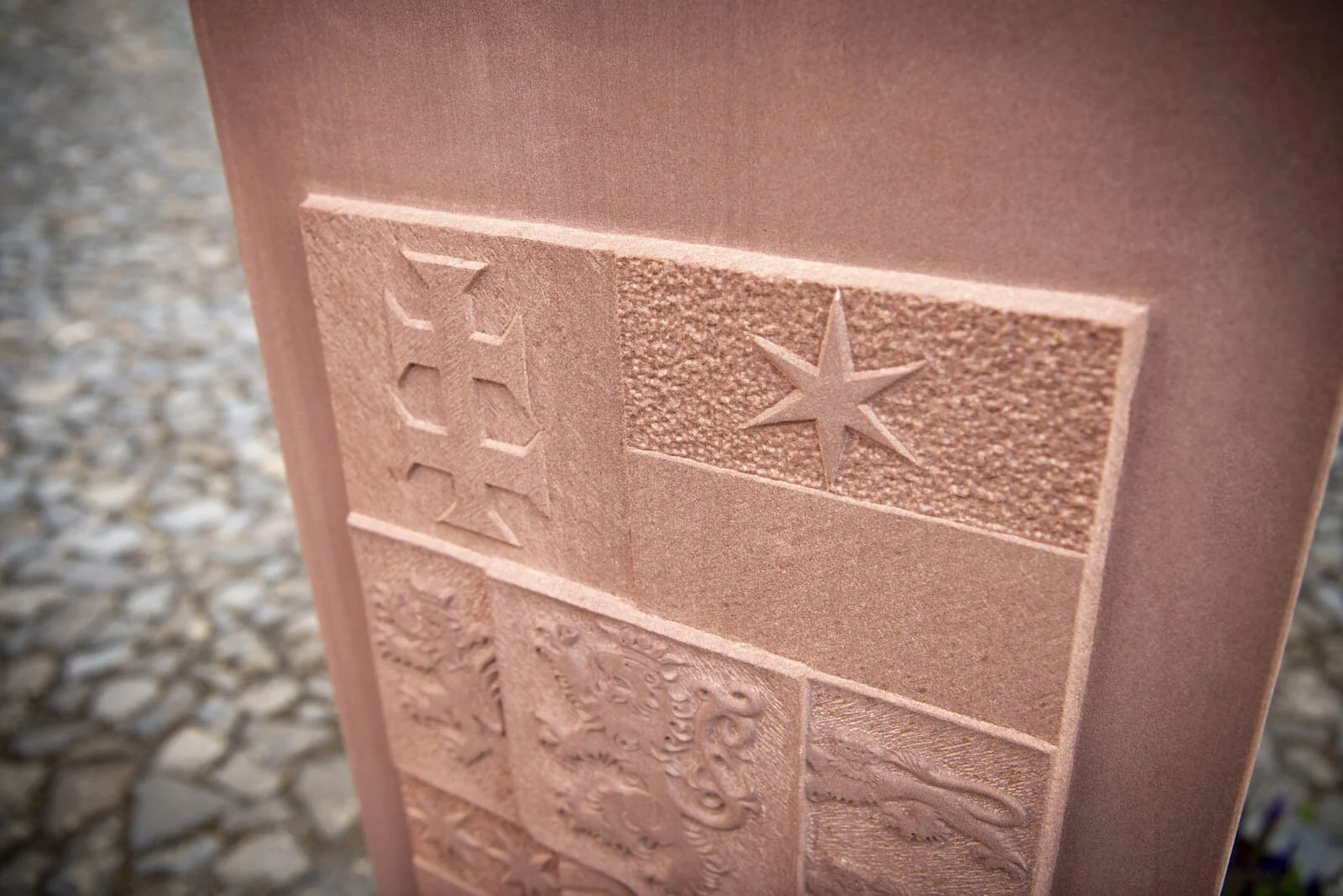 Detail des Wappens mit Kreuz und einem Stern im Relief