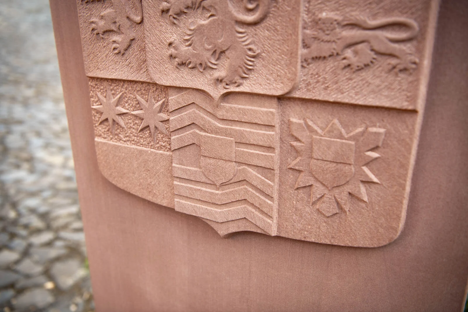 Kleindenkmal in Speckswinkel: Wappen mit Löwen und Sternen als Relief im rötlichen Stein