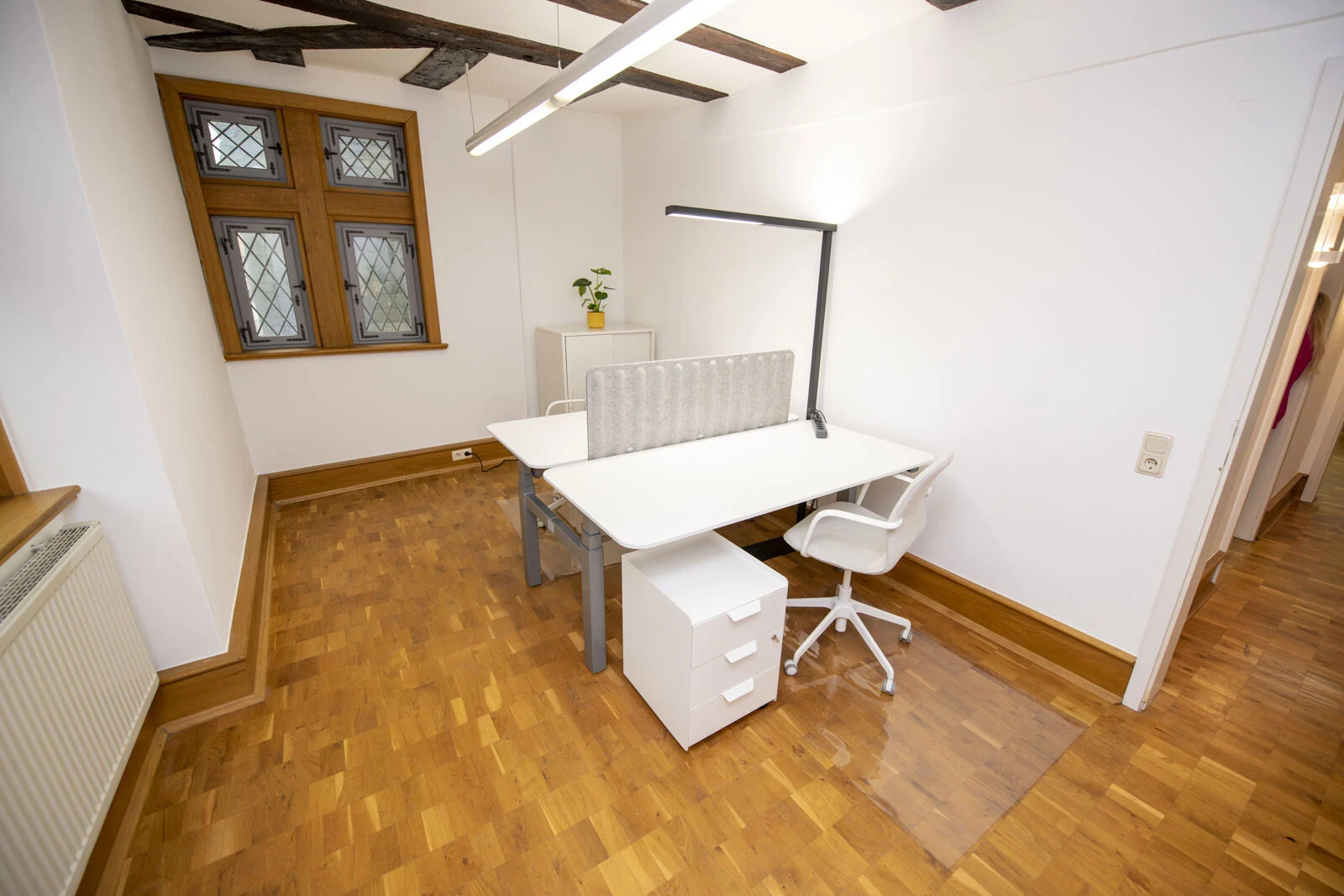 Kleines Einzelbüro mit Schreibtisch, Rollcontainer und Bürostuhl