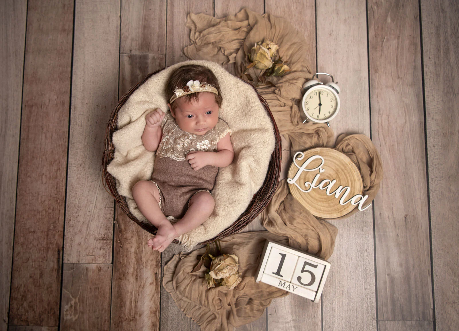 Babyfotografie von oben: Baby im Korb mit Wecker, Namensschild aus Holz und Datumswürfeln