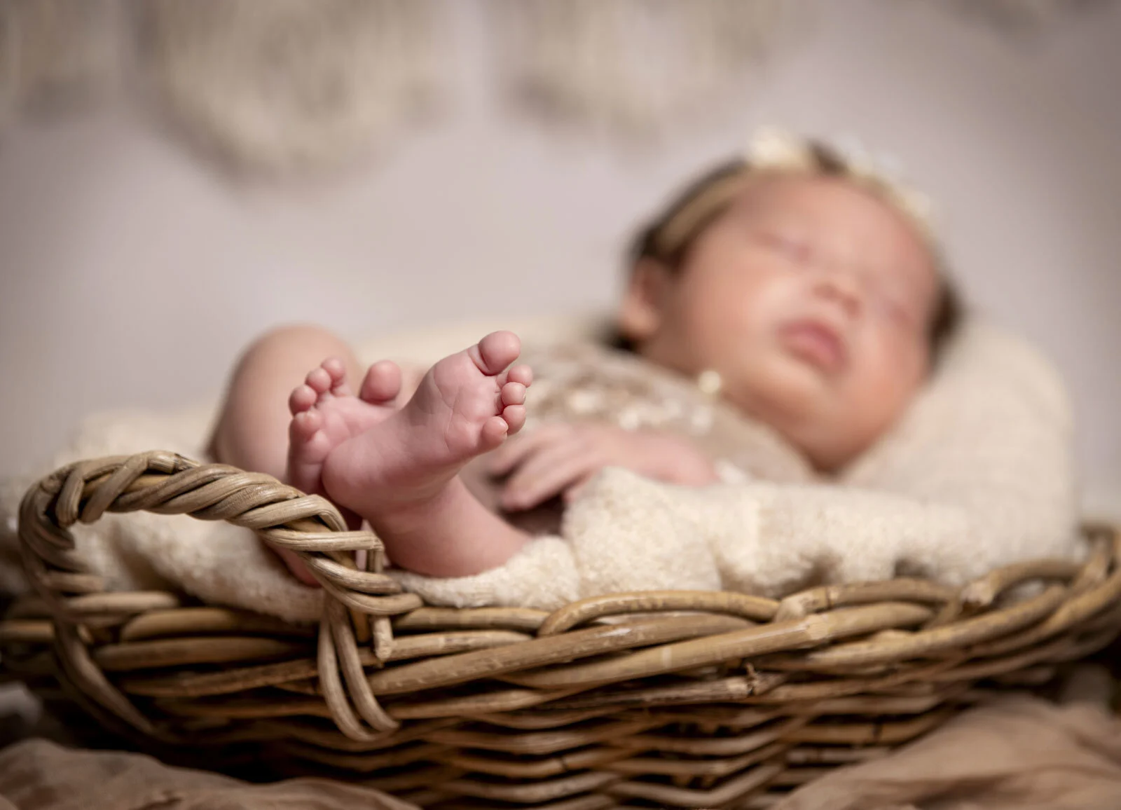 Nahaufnahme der kleinen Füße eines schlafenden Babys im Korb