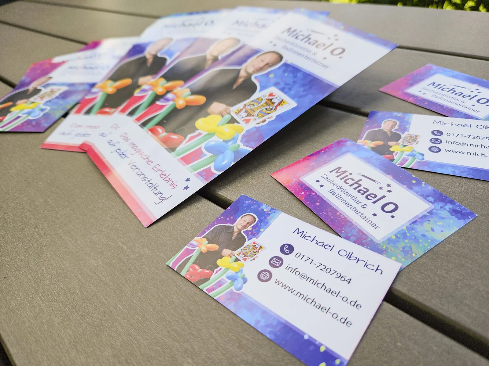 Autogrammkarten und Visitenkarten im neuen Design, im Hintergrund Flyer