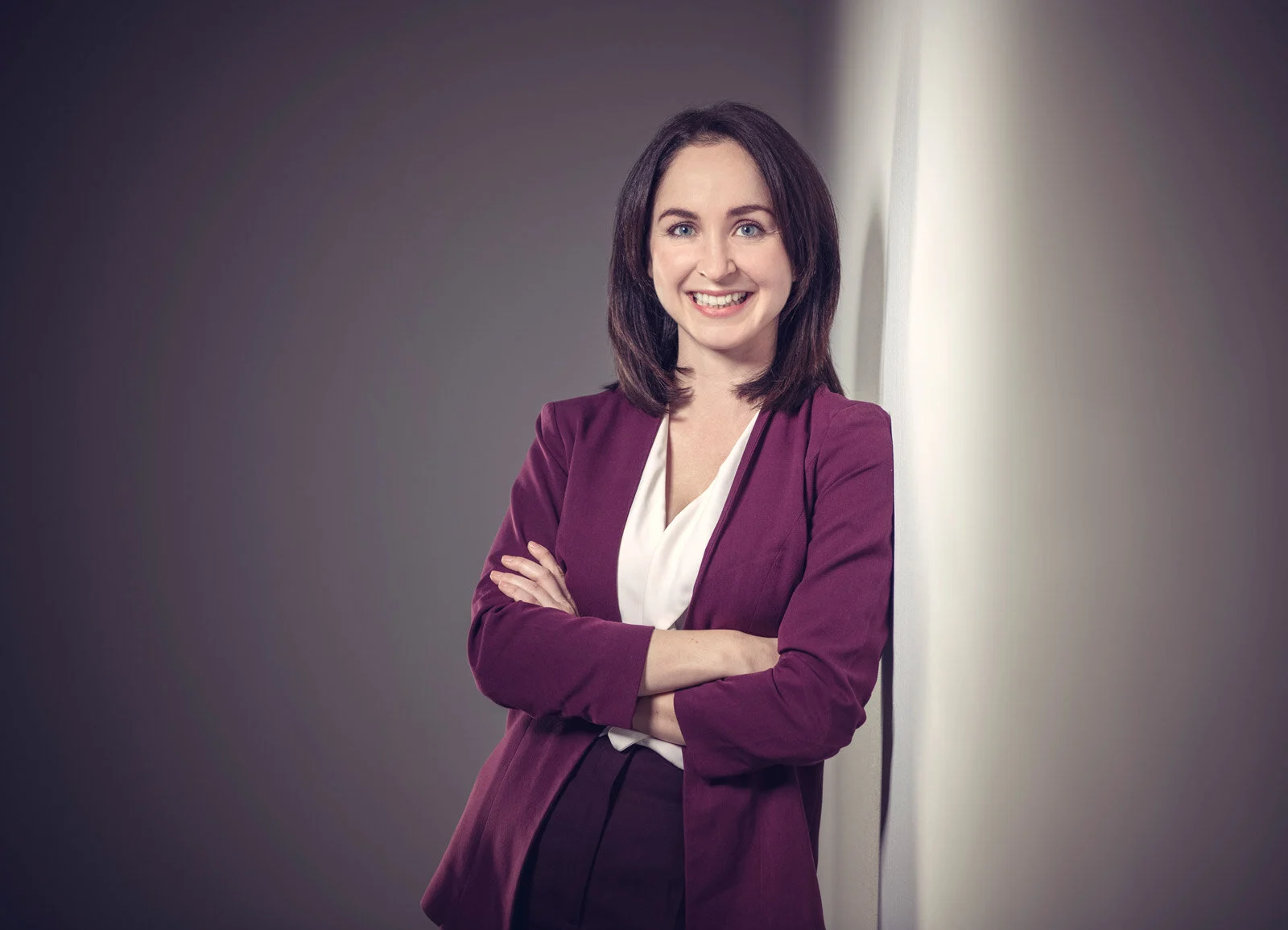 portrait fotos fotostudio marburg | Peter Lauritis Photography Portraitfoto einer Frau im bordeauxroten Blazer mit verschränkten Armen