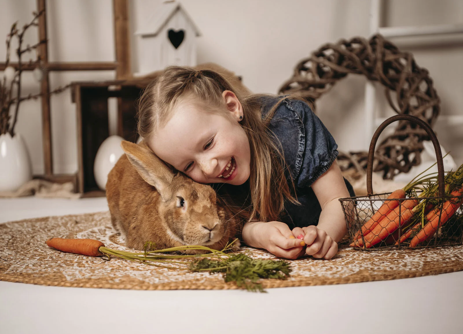 Frühlingshafte Kinderfotos: Mädchen kuschelt lachend mit dem Kopf an Hoppelhase Hans