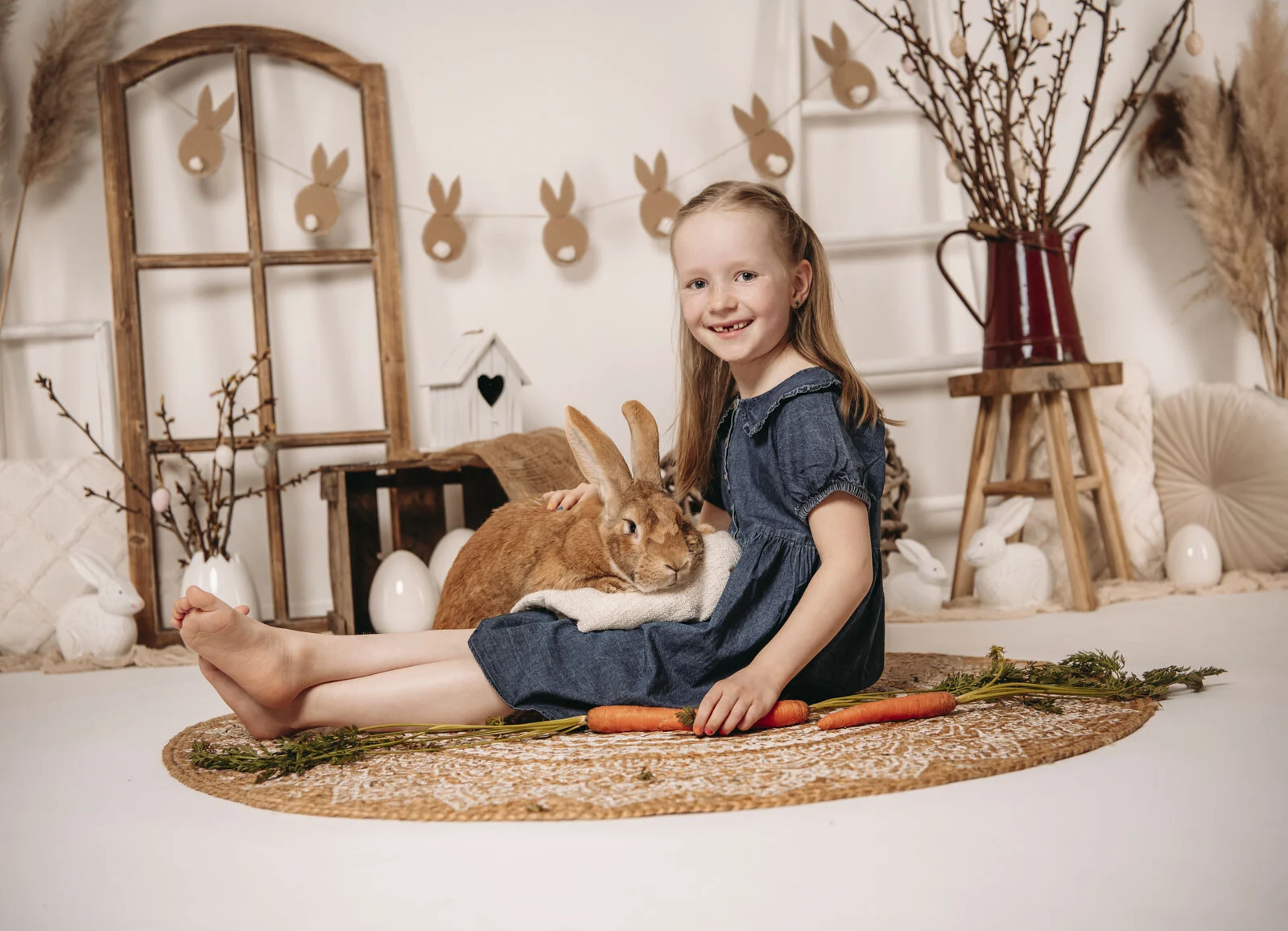 Frühlingshafte Kinderfotos: Mädchen sitzt auf dem Teppich, Hoppelhase Hans dicht neben ihr