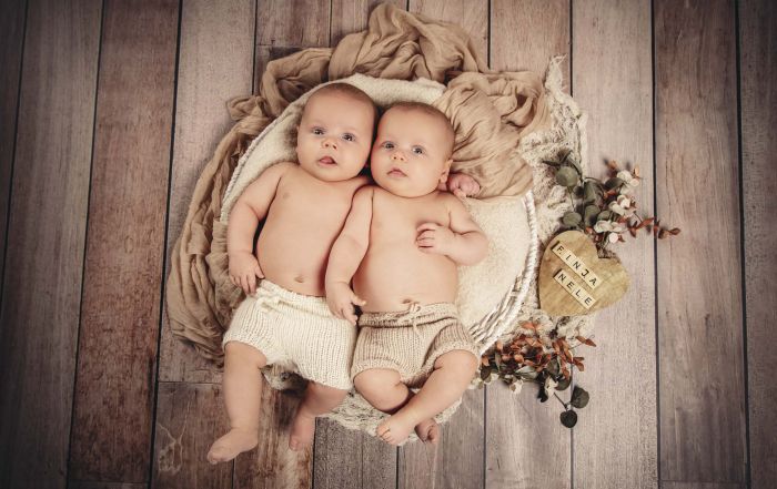 Zwillinge liegen in einem Körbchen im Fotostudio
