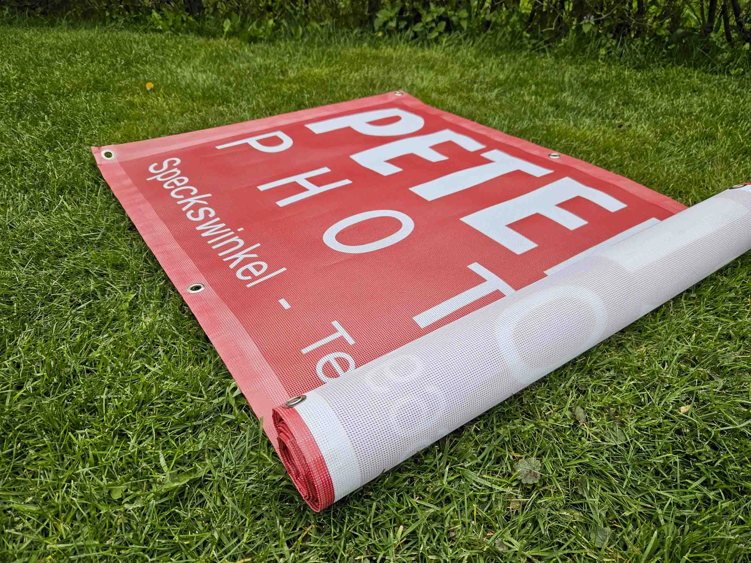 Rotes Werbebanner wird auf dem Rasen ausgerollt