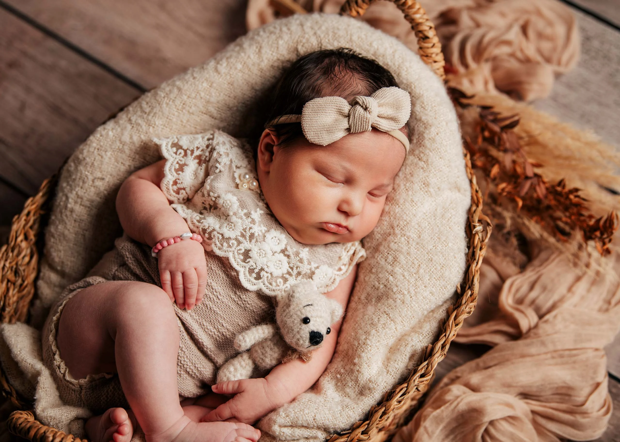 Babyfotos Neugeborene Fotogalerie 034 | Peter Lauritis Photography Schlafendes Neugeborenes im Spitzenbody liegt zusammengerollt im Korb