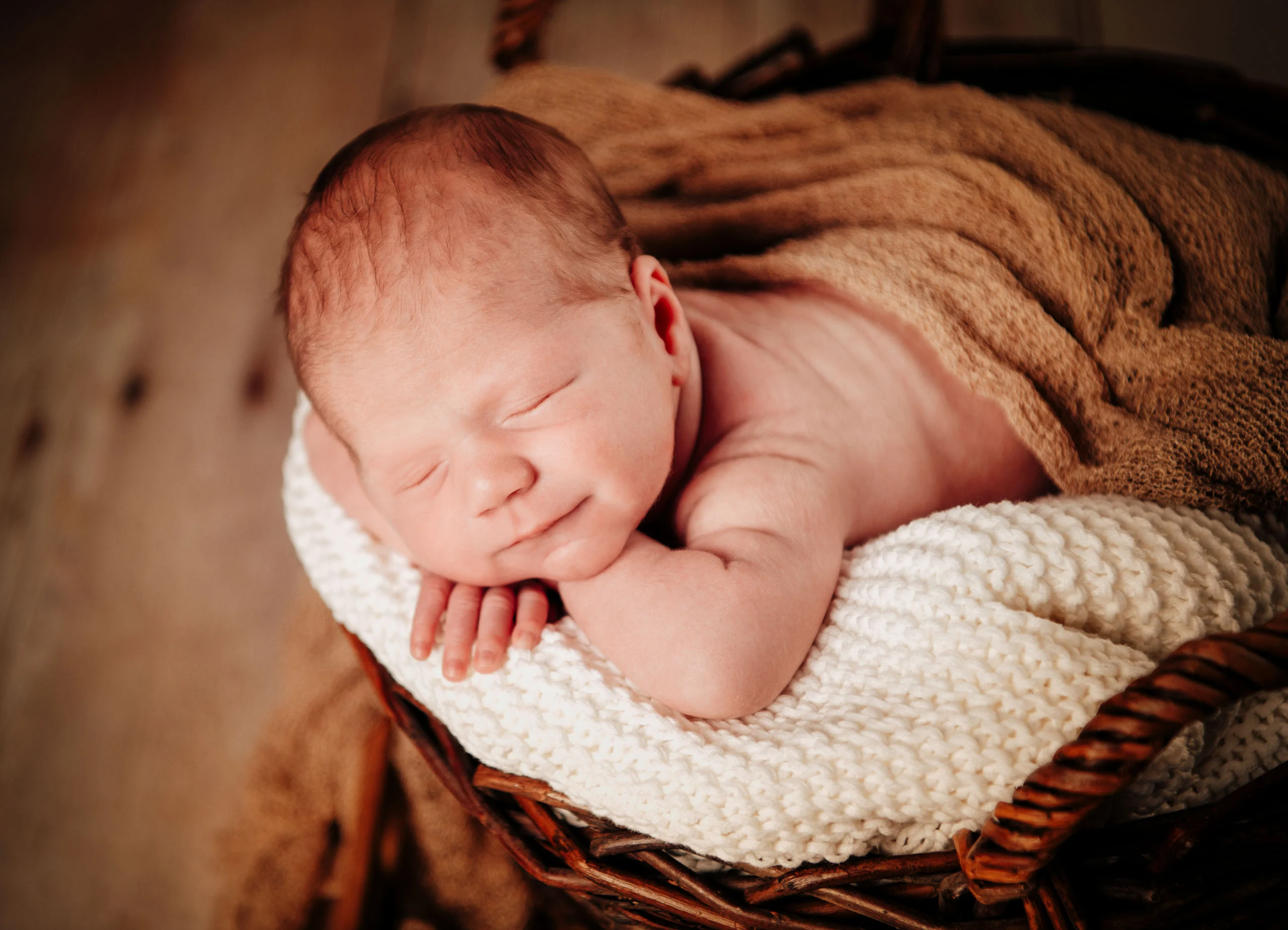 Babyfotos Neugeborene Fotogalerie 039 | Peter Lauritis Photography Schlafendes Neugeborenes liegt mit dem Kinn auf den Händen auf einer Strickdecke