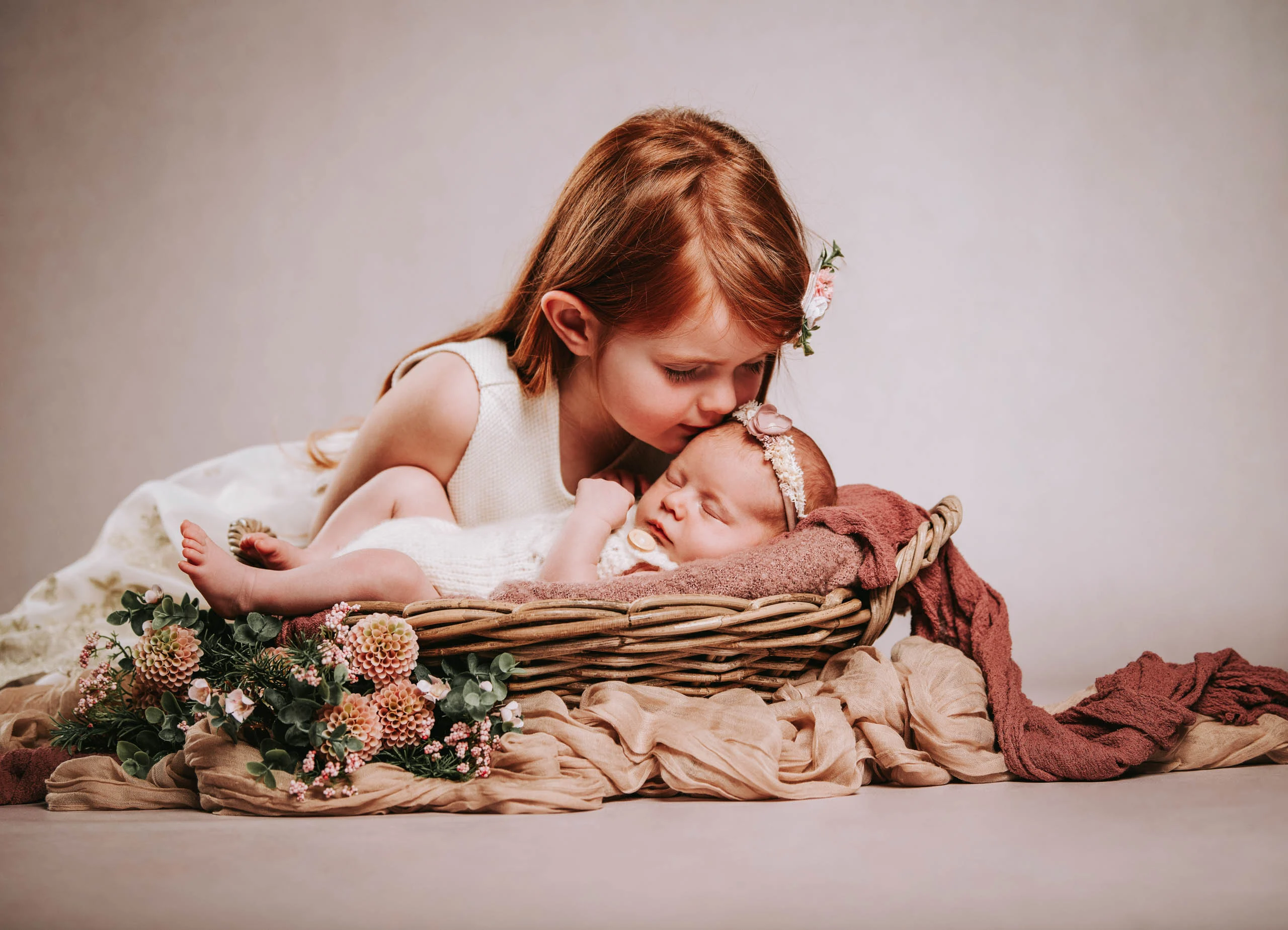 Babyfotos Neugeborene Fotogalerie 041 | Peter Lauritis Photography Mädchen küsst das Neugeborene im Korb zwischen Blumen