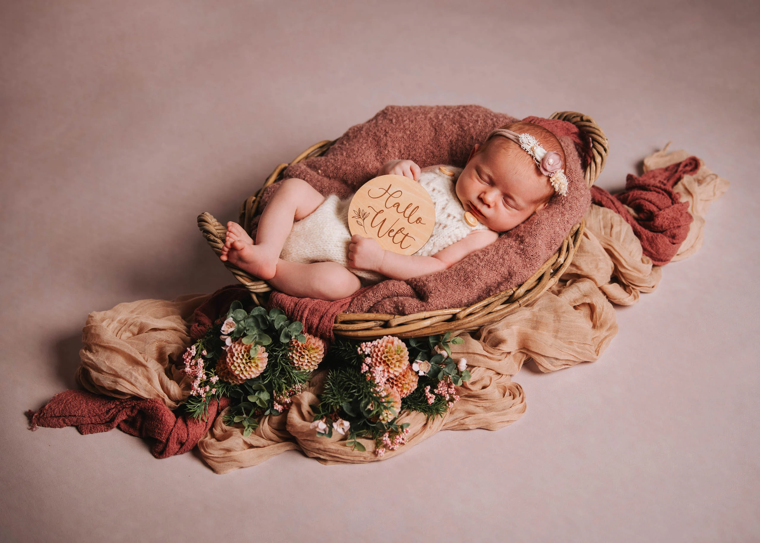 Babyfotos Neugeborene Fotogalerie 042 | Peter Lauritis Photography Neugeborenes mit Holzschild schläft in einem Korb mit rosa Tüchern