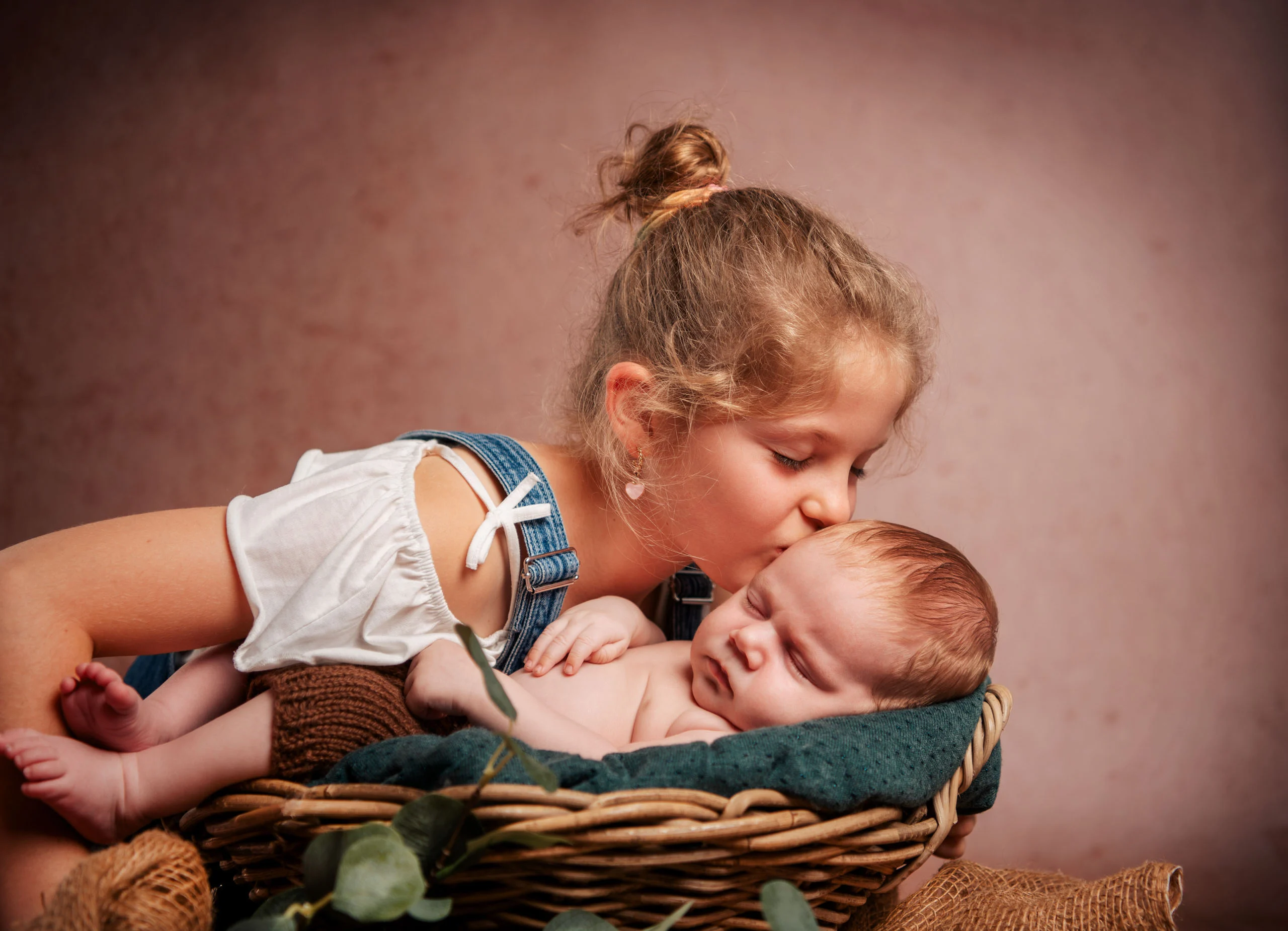 Babyfotos Neugeborene Fotogalerie 044 | Peter Lauritis Photography Mädchen mit Haarknoten küsst das schlafende Baby